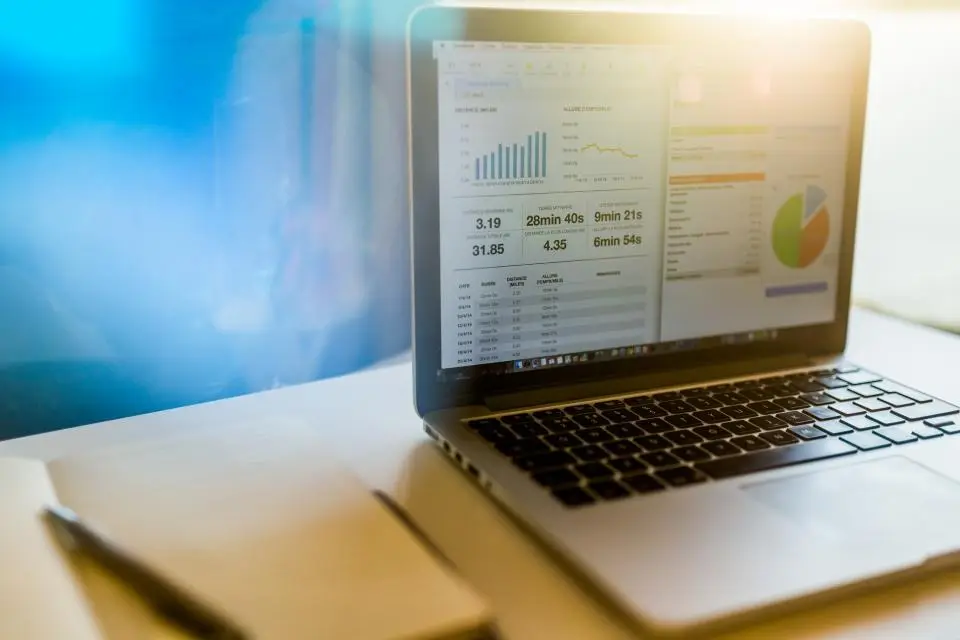 Notebook aberto exibindo gráficos e indicadores financeiros