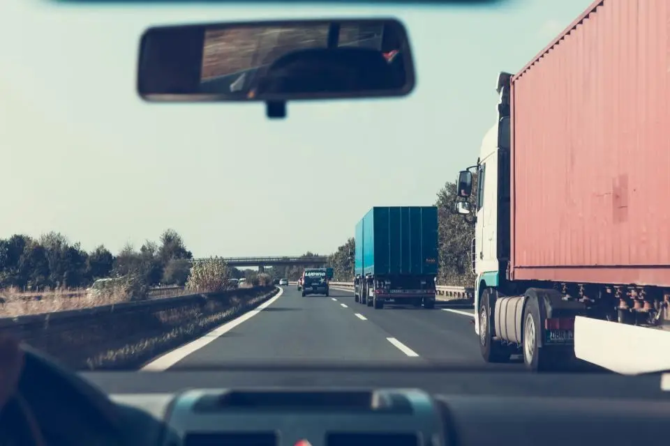 Caminhões de carga na rodovia, vistos de dentro de outro veículo